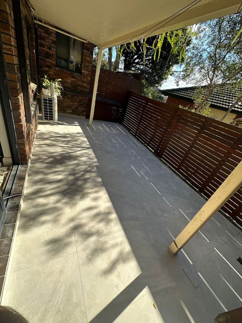 Light large-format tiles across a covered outdoor area