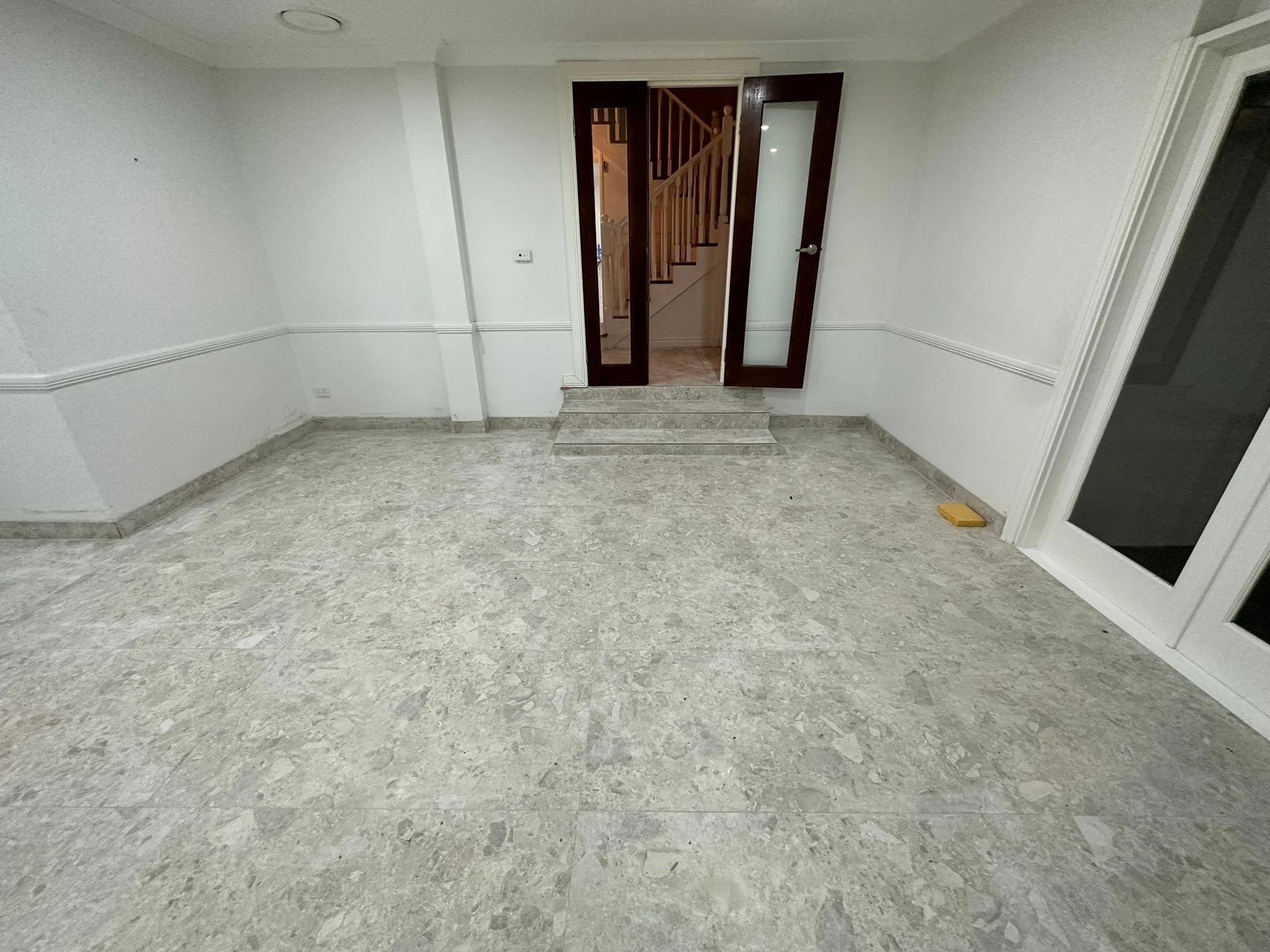 Pale stone-look floor tiles through an interior room
