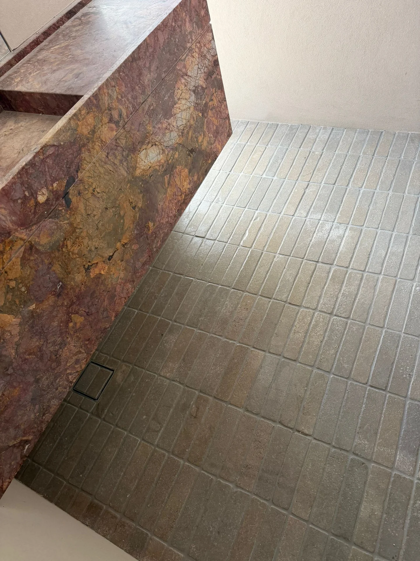 Narrow rectangular bathroom floor tiles beside a stone-look vanity