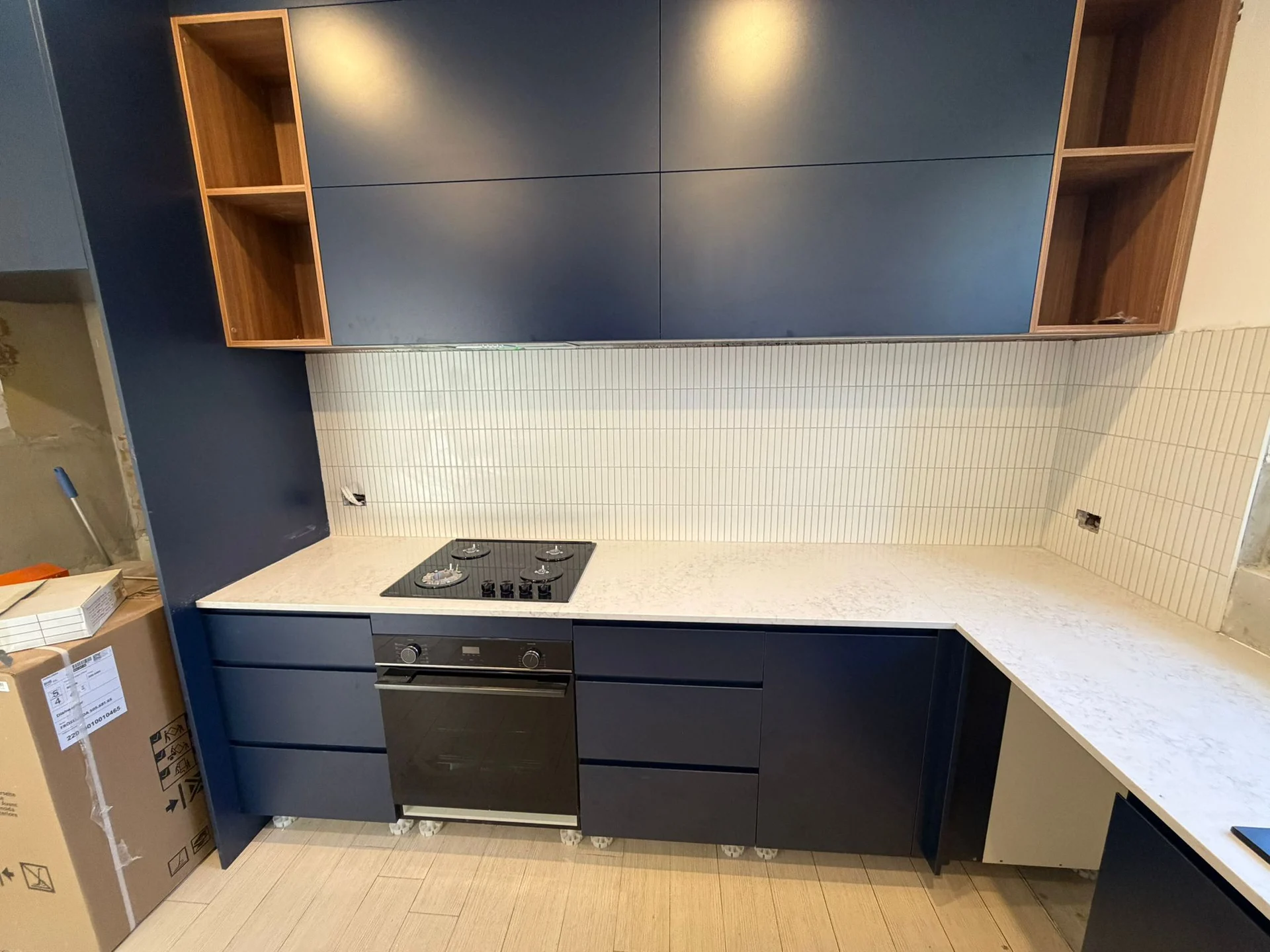 White vertical splashback tiles behind a kitchen cooktop